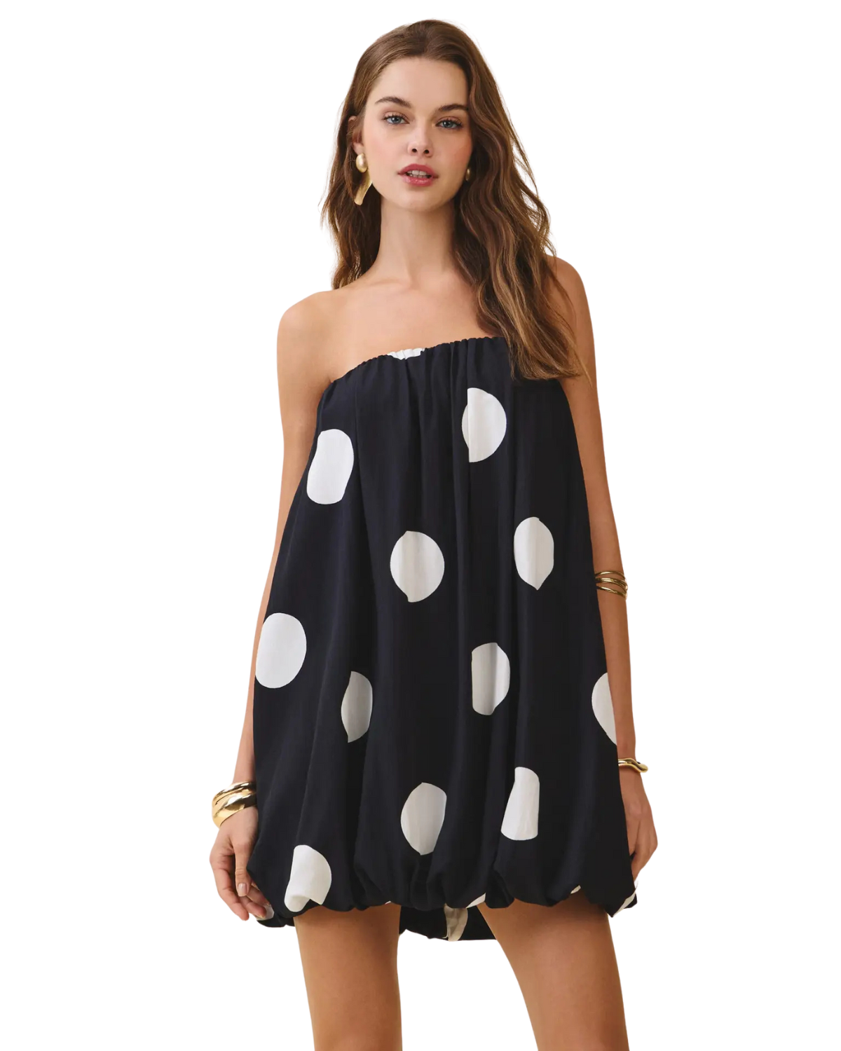 Girl in black and white polka dot dress on white background