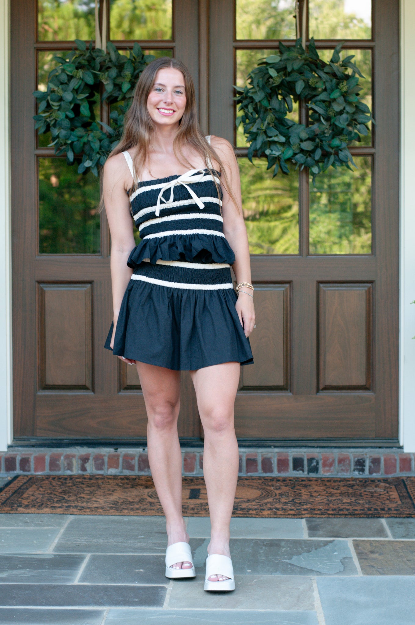 Woman in a black and white striped mini skirt set with rouched top and skirt band