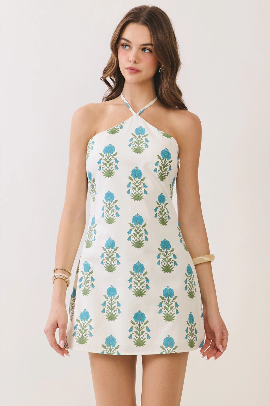 Woman wearing a floral halter dress on a white background