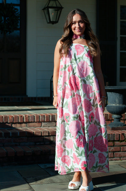 Woman wearing floral a-line dress in front of a white porch