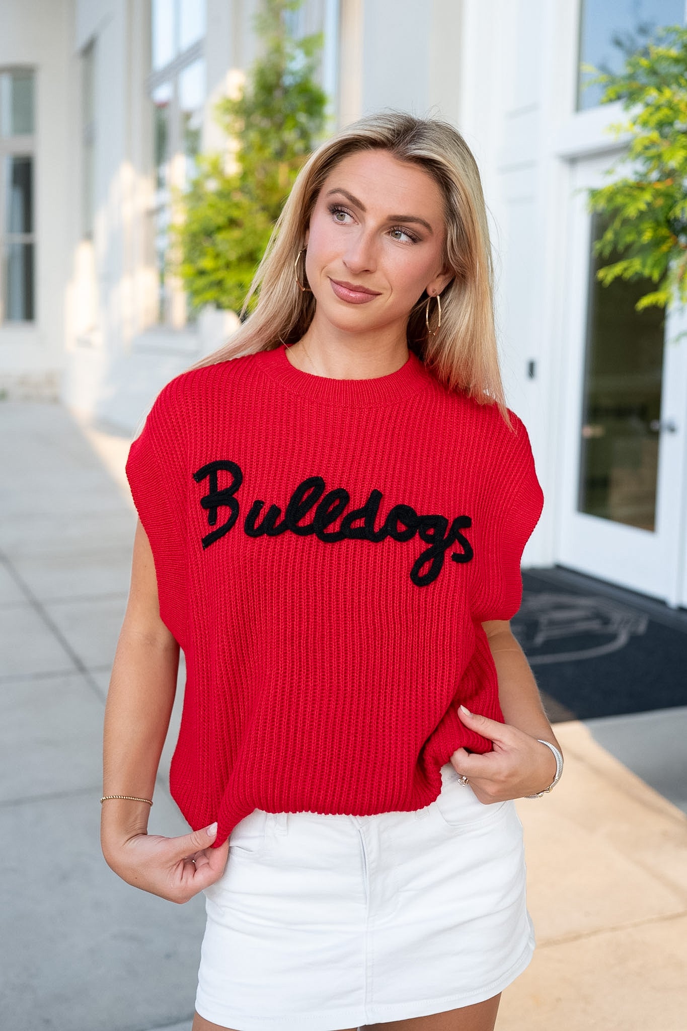 Girl wearing a red Bulldogs ribbed sweater standing on a patio