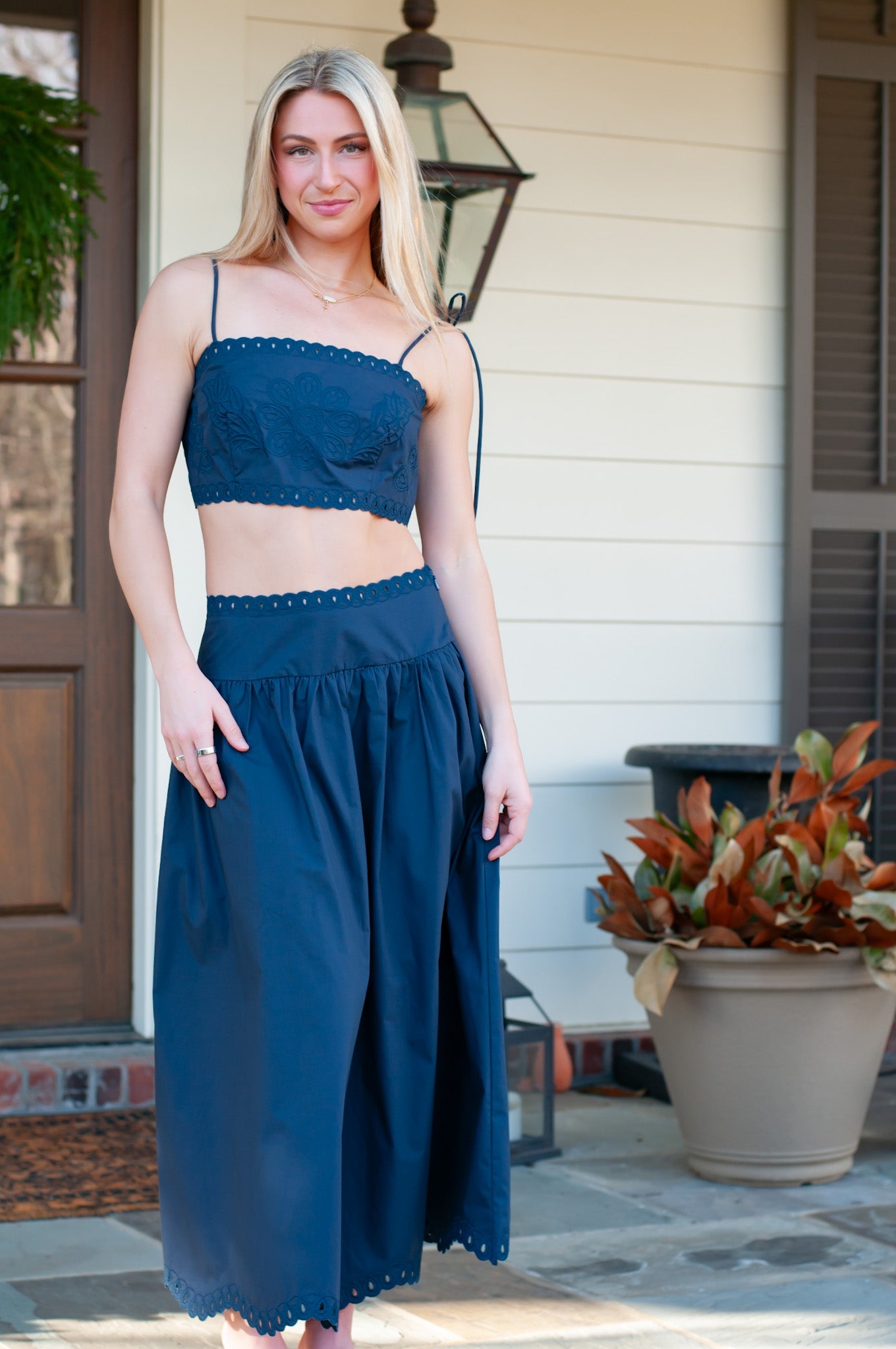 Woman wearing a blue skirt set standing on a porch